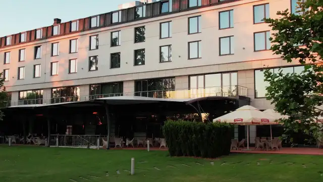 Nowoczesny hotel z tarasem i ogródkiem, gdzie można usiąść. Czy to jeden z hoteli Hilton w Warszawie?