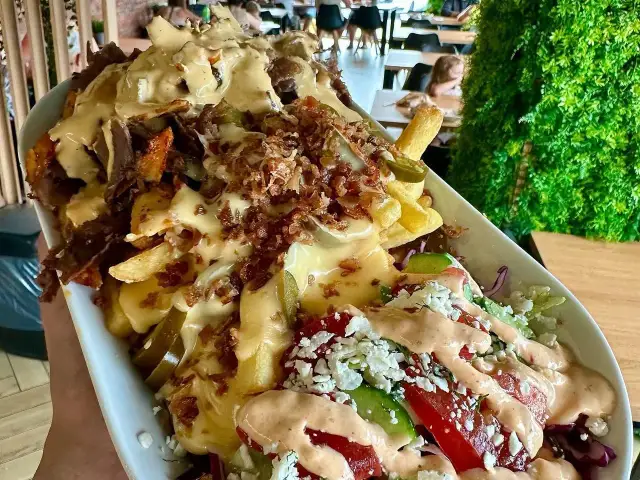 Piri piri kebab gdzie jest? Ogromna porcja frytek z mięsem, serem, jalapeno i sosem. Obok świeża sałatka z fetą.