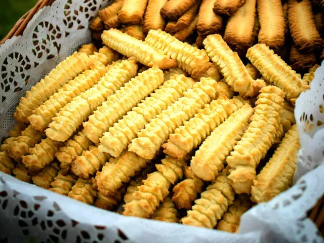 Koszyk pełen domowych, złocistych ciasteczek o charakterystycznym, karbowanym kształcie.