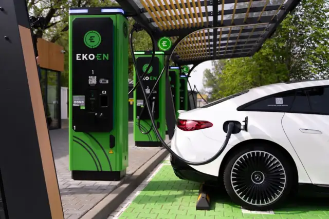 Nowoczesna stacja ładowania EKOEN. Dowiedz się, jak otworzyć stację ładowania samochodów elektrycznych, podłączając białe auto.
