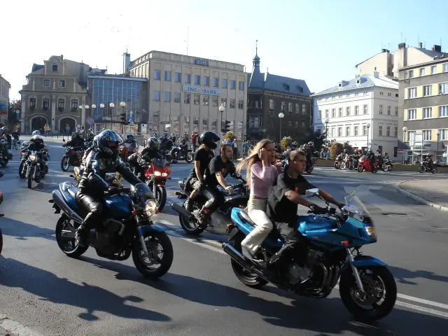 Zloty motocyklowe w mieście. Grupa motocyklistów w kaskach i skórzanych ubraniach przemierza ulicę na swoich maszynach.