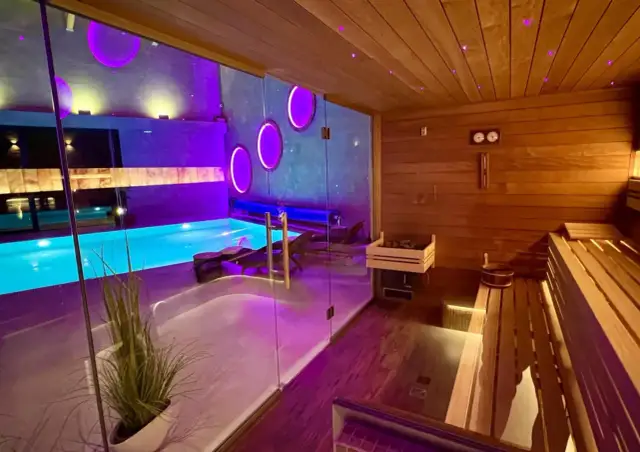 Relaks w spa w Rudzie Śląskiej: basen z niebieską wodą i nowoczesna sauna z drewnianymi ławami.