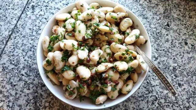 Miseczka fasoli Jaś z natką pietruszki i suszonymi pomidorami.