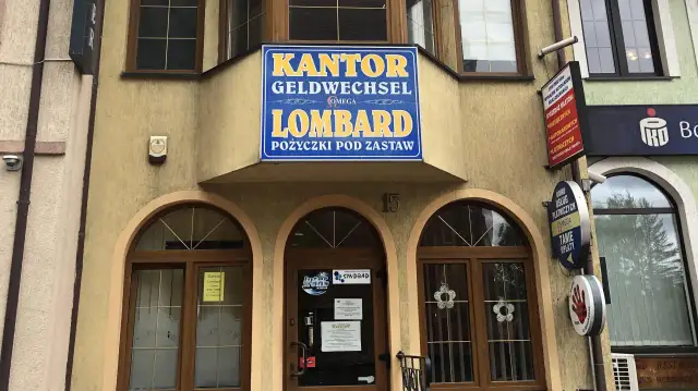 Elewacja budynku z szyldem "KANTOR GELDWECHSEL LOMBARD POŻYCZKI POD ZASTAW".