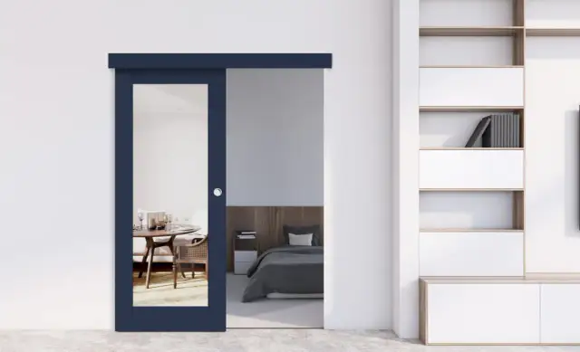 Granatowe drzwi przesuwne z lustrem oddzielają jadalnię od sypialni. Czy drzwi przesuwne są szczelne? Wyglądają na solidne.