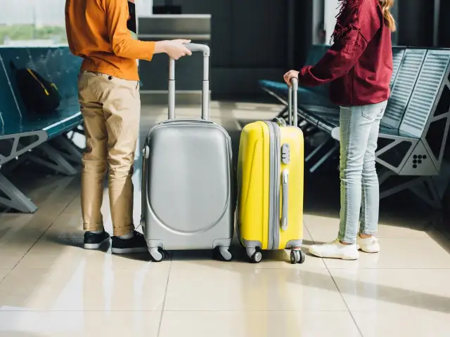 Dzieci z walizkami na lotnisku.