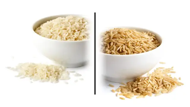 Dwie miseczki z ryżem: biały i brązowy, na białym tle.