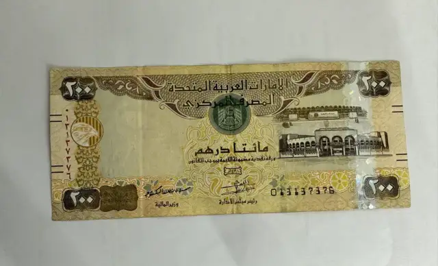 Banknot 200 dirhamów, czyli waluta w Dubaju. Widoczny orzeł i budynek.