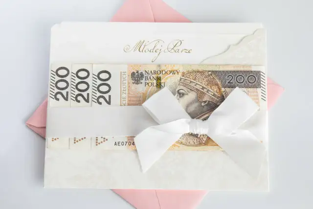 Elegancka koperta z napisem "Młodej Parze", ozdobiona banknotami 200 zł i białą wstążką. Idealny sposób, jak udokumentować pieniądze z wesela.