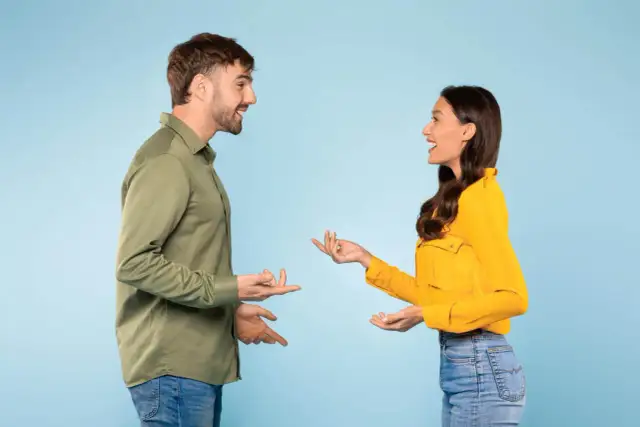 Mowa ciałem mężczyzny i kobiety wesoło rozmawiających, gestykulując dłońmi.