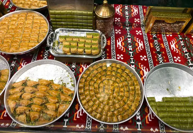 Tureckie jedzenie: bogactwo baklawy i pistacjowych przysmaków na kolorowym obrusie.