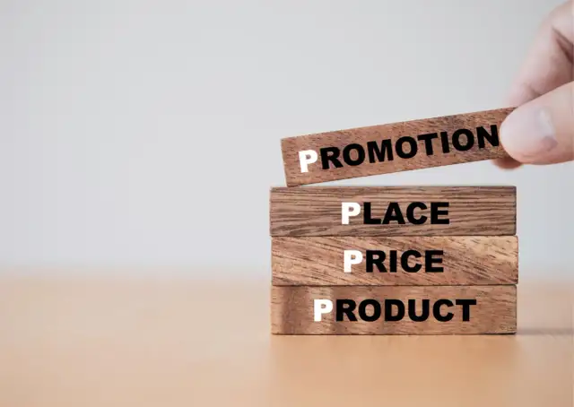 Drewniane klocki z napisami: Product, Price, Place, Promotion.