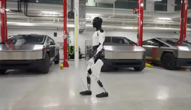 Optimus, robot Tesli, spaceruje obok Cybertrucków. Elon Musk marzy o przyszłości.