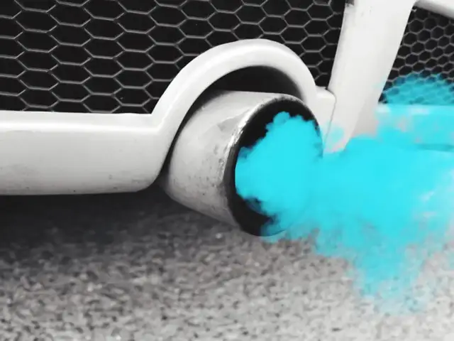 Niebieski dym z wydechu samochodu, gdy silnik spala benzynę.