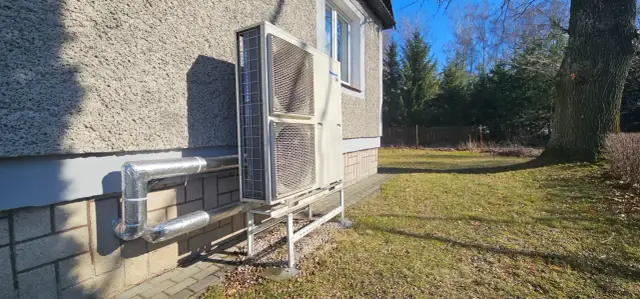 Pompa ciepła Panasonic zamontowana przy nowym domu. Instalacja zasilana dzięki dotacji, zapewnia ekologiczne ogrzewanie.