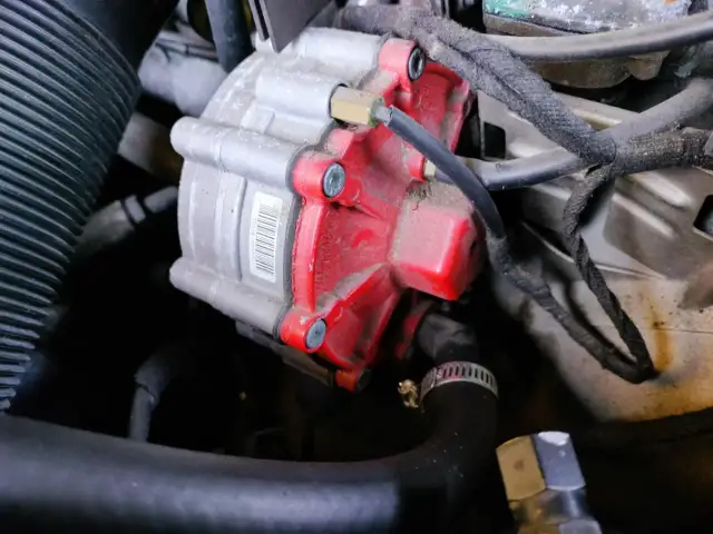 Część silnika LPG z czerwonym elementem i przewodami.