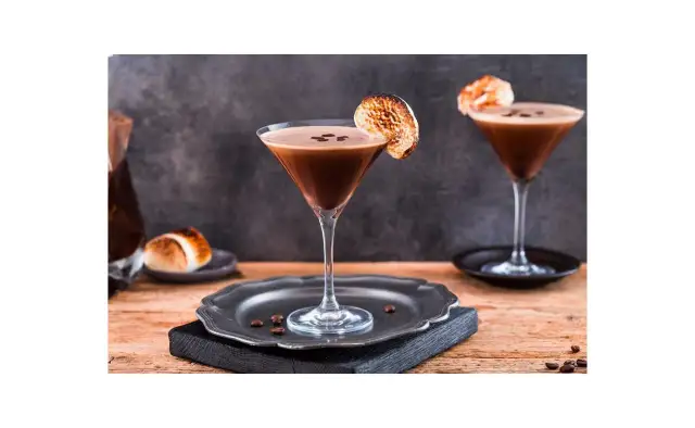 Espresso Martini przepis: dwa eleganckie kieliszki z kawowym drinkiem, ozdobione palonymi piankami i ziarnami kawy. Idealny na wieczór.