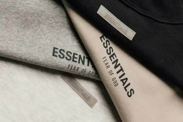 Ubrania marki Essentials, znanej z minimalistycznego stylu i jakości, w odcieniach szarości, beżu i czerni.