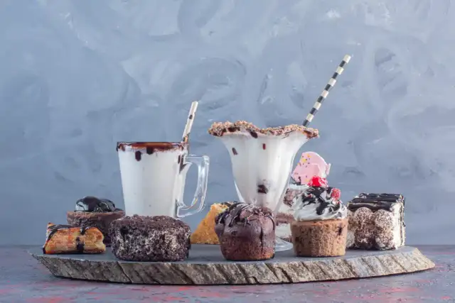 Słodkie desery i koktajle na kamiennej desce.