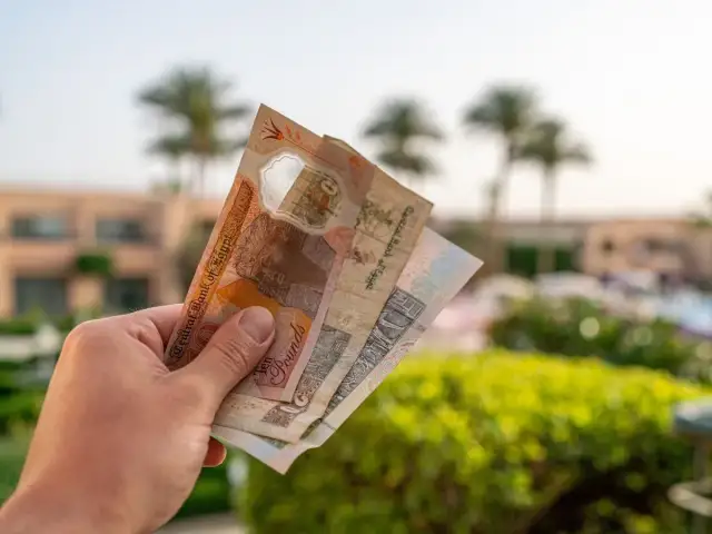 Dłoń trzyma egipskie funty. Czy w Egipcie można płacić euro? Lepiej mieć lokalną walutę, by uniknąć problemów.