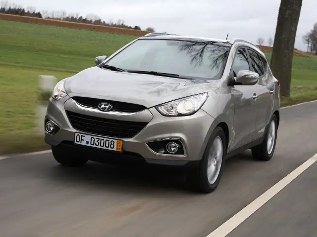 Szary Hyundai ix35 w ruchu drogowym, przód samochodu.