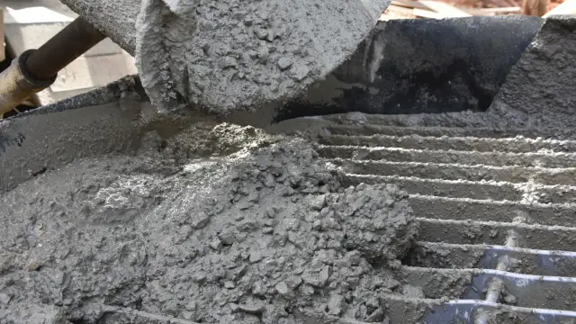 Świeży, mokry beton z kruszywem wylewany na ruszt.