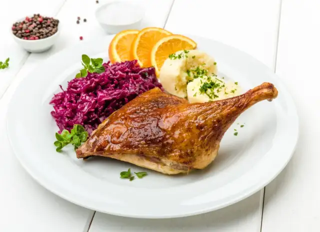 Pieczona kaczka z purée, czerwoną kapustą i pomarańczą. Marynata do kaczki nadała jej złocisty kolor i apetyczny połysk.