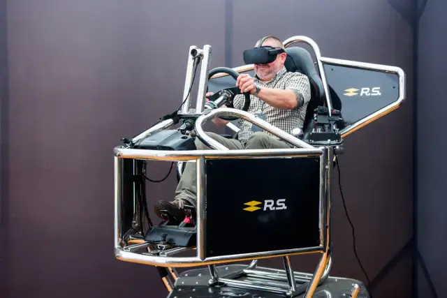 Mężczyzna w goglach VR przeżywa swoje **speed dreams** na symulatorze wyścigowym.