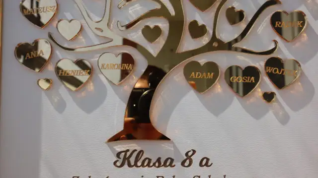 Złote serca z imionami uczniów na tle drzewa, pod napisem "Klasa 8 a".