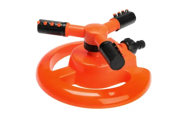 Pomarańczowy zraszacz rotacyjny z trzema ramionami i czarnymi dyszami na białym tle.