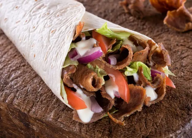 Domowy kebab w tortilli z mięsem, warzywami i sosem. Prosty przepis na to, jak zrobić kebab w domu.