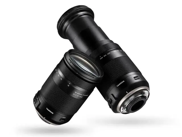 Dwa obiektywy Tamron 18-400 mm, jeden z wysuniętym zoomem, drugi z zasuniętym, unoszą się na białym tle.