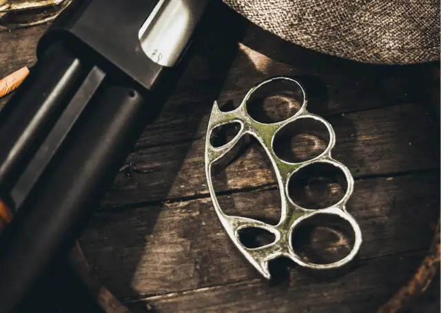 Kastet i fragment broni na drewnianym tle.