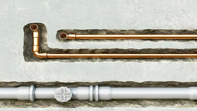 Miedziane i białe rury hydrauliczne w ścianie.