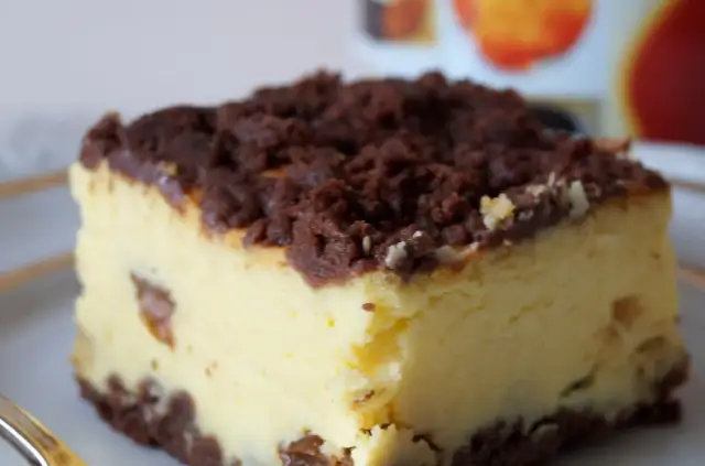 Kawałek sernika królewskiego ze starym przepisem, z czekoladową kruszonką i rodzynkami.