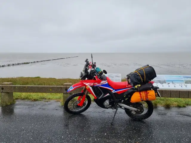 Czerwony motocykl przygotowany na podróż motocyklem nad morze, zapakowany i gotowy do drogi.