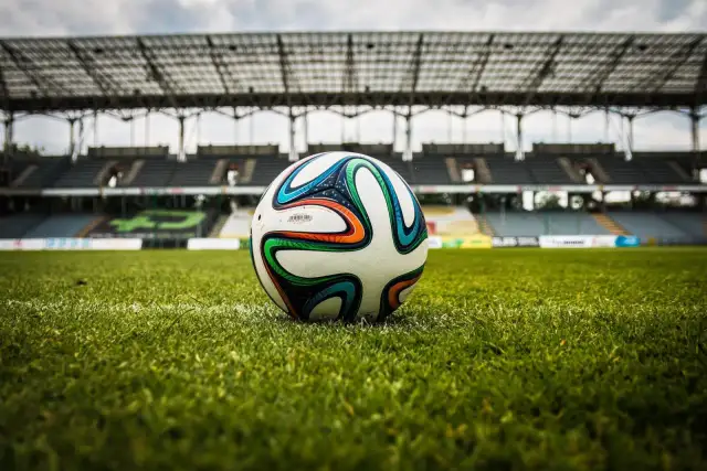 Piłka na murawie stadionu, gotowa do gry. Czekamy na sygnał, by dowiedzieć się, ile trwa dogrywka w piłce nożnej.