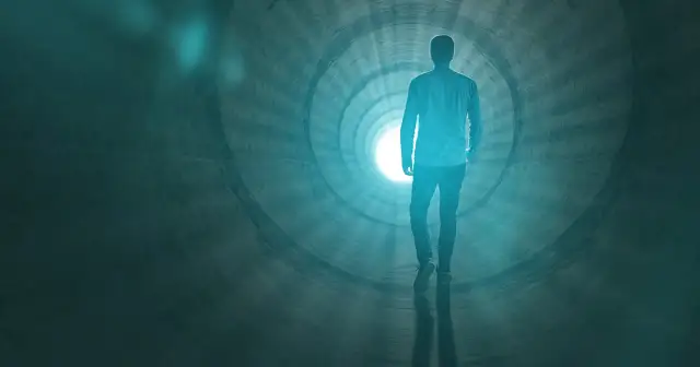 Człowiek idzie w stronę światła w tunelu, symbolizującym to, co się dzieje po śmierci.