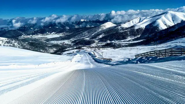 Idealne warunki na narty w Gruzji. Przygotowany stok z widokiem na ośnieżone góry i dolinę.