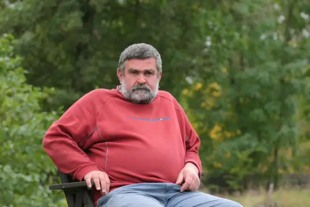 Mężczyzna z siwą brodą w czerwonej bluzie siedzi na ławce. Spogląda wprost, jakby chciał powiedzieć: jeszcze jest czas.