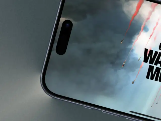 Telefon z ekranem gry Call of Duty Warzone Mobile. Widać spadające postacie z czerwonymi smugami dymu na tle burzowych chmur.