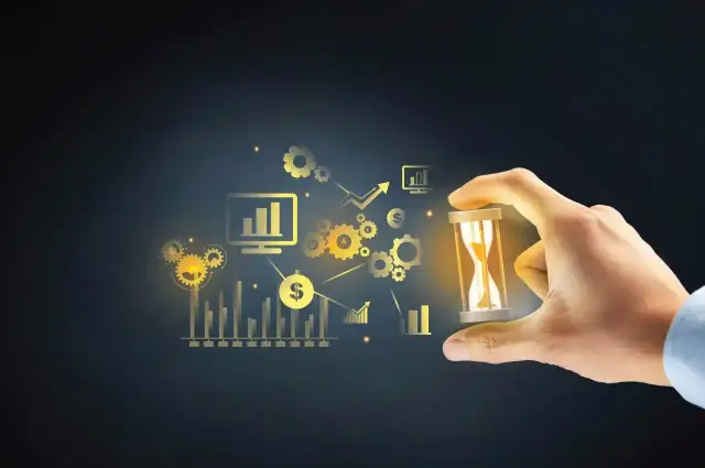 Dłoń trzyma klepsydrę na tle wykresów i ikon symbolizujących czas i procesy.