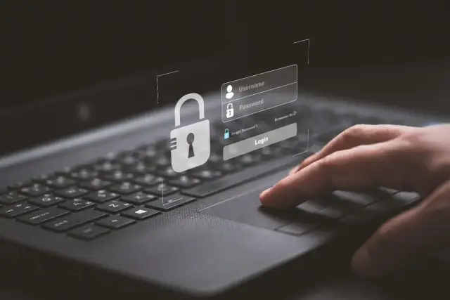 Dłoń na klawiaturze, ekran logowania z kłódką. Chcesz wiedzieć, jak wyłączyć wyszukiwanie AI? Zabezpiecz swoje dane.