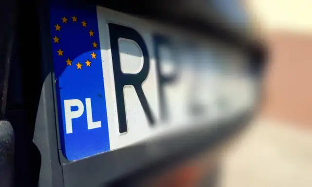 Zbliżenie na polską tablicę rejestracyjną z symbolem UE. To ważny moment, pierwsza rejestracja samochodu.