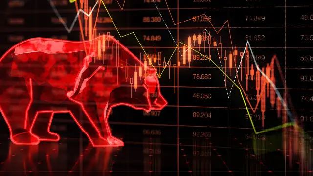 Czerwony niedźwiedź symbolizuje bessę na wykresie giełdowym, gdzie ceny spadają.