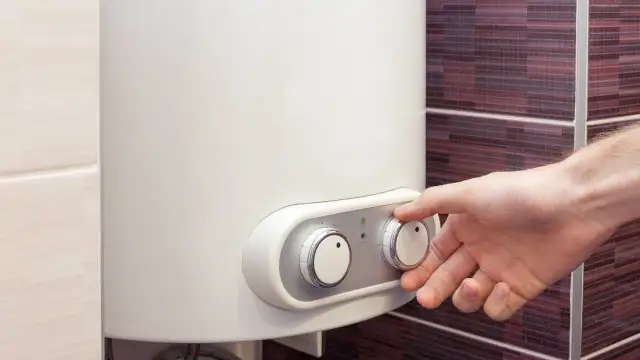 Dłoń reguluje temperaturę na bojlerze elektrycznym 40l energooszczędnym.