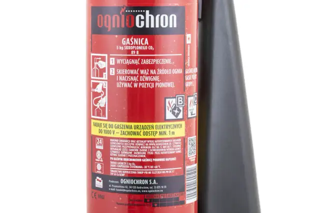 Czerwona gaśnica śniegowa z czarną dyszą i instrukcją obsługi.