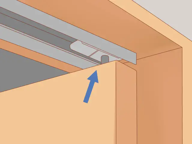 Szczegół mechanizmu do regulacji drzwi przesuwnych w szafie. Strzałka wskazuje kierunek podnoszenia.