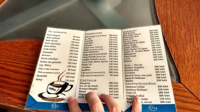 Menu z Albanii: ceny alkoholi. Widoczne są ceny whisky, ginu, rumu, grappy, ouzo i raki.
