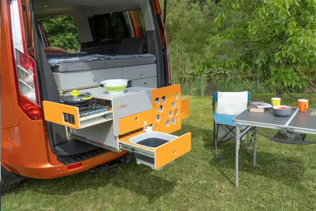 Wysuwany kamper box z kuchenką i zlewem, gotowy do użycia na biwaku.